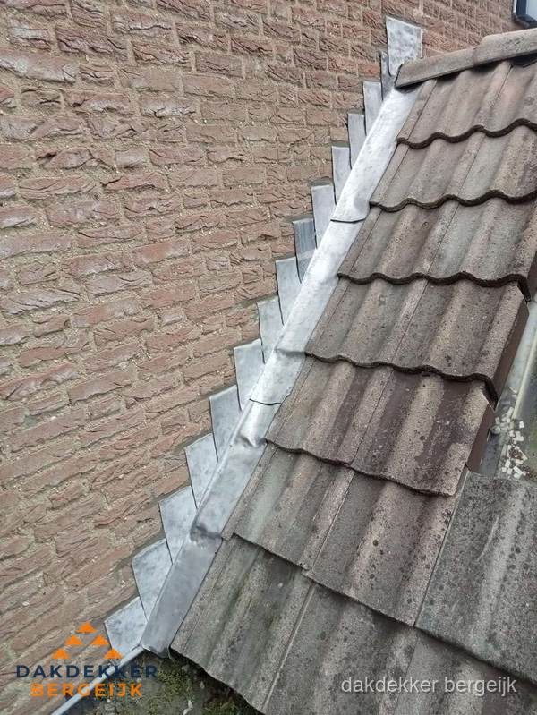 Loodslabben langs dakaansluiting bij bakstenen muur in Bergeijk