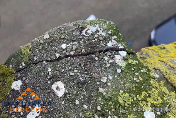 Beschadigde en verweerde nokvorst met scheuren en mos in Bergeijk