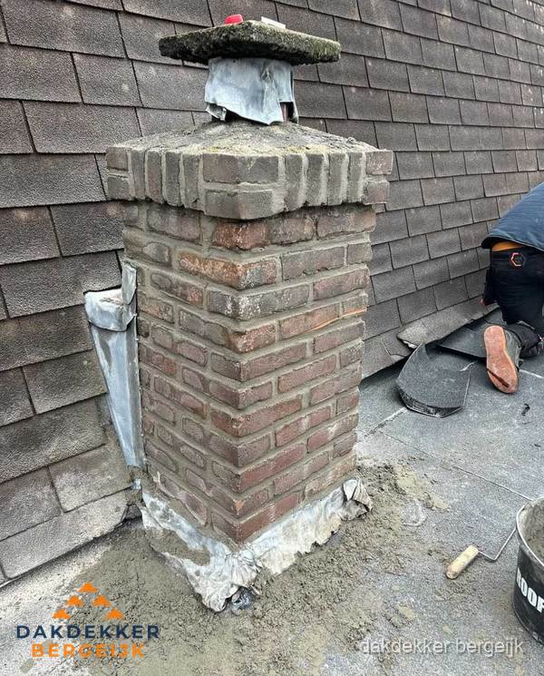 Schoorsteen reparatie met lood en voegwerk op leien dak in Bergeijk
